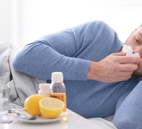 Mann liegt mit Erkältung im Bett Immunsystem Männer