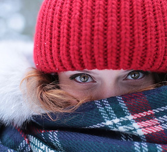 Frau mit Haube und Schal Warme Kleidung bei Erkältung